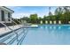 Community pool with shallow stairs, stainless-steel railings, and several lounge chairs at 256 Epping Dr, Stockbridge, GA 30281