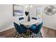 Stylish dining area features a round marble table, blue chairs, and modern decor at 256 Epping Drive, Stockbridge, GA 30281
