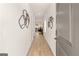Long hallway with wood floors, white walls, and decorative metal wall art at 256 Epping Drive, Stockbridge, GA 30281