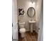 Elegant powder room featuring a pedestal sink, round mirror, and neutral decor for a clean and sophisticated look at 256 Epping Drive, Stockbridge, GA 30281