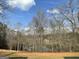 View of the backyard lined with bare trees and a glimpse of the serene lake beyond at 637 Lakeview Dr, Newborn, GA 30056
