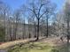 View of fenced in back yard with trees that offer a view of the lake at 637 Lakeview Dr, Newborn, GA 30056
