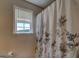 Bathroom detail showcasing floral shower curtain and natural light streaming through the window at 637 Lakeview Dr, Newborn, GA 30056
