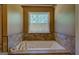 A luxurious bathtub is set against tiled walls with a view of the outdoors at 637 Lakeview Dr, Newborn, GA 30056