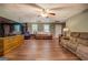 Spacious living room with wood flooring, a ceiling fan, and multiple seating areas at 637 Lakeview Dr, Newborn, GA 30056