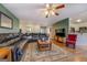 A living room featuring hardwood floors, furniture, a ceiling fan, and an adjacent kitchen at 637 Lakeview Dr, Newborn, GA 30056