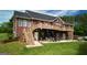 Two-story brick home featuring a large deck, patio, and well-maintained lawn, perfect for outdoor enjoyment at 637 Lakeview Dr, Newborn, GA 30056