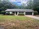 Charming single-story home featuring a dark roof, manicured shrubs, and an attached two-car garage at 120 Lazy Hollow Ln, Covington, GA 30016