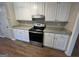 Stylish kitchen boasts granite counters, white cabinets, stainless steel appliances, and wood-look floors at 120 Lazy Hollow Ln, Covington, GA 30016