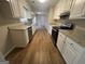 Well-lit kitchen with white cabinets, granite countertops, stainless steel appliances, and wood flooring at 120 Lazy Hollow Ln, Covington, GA 30016