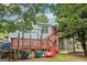 Backyard view featuring the home's deck, patio, and surrounding green space and trees at 1152 Sunday Ln, Jonesboro, GA 30238