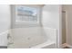 Bright bathroom featuring a built-in white bathtub beneath a window, creating a serene and well-lit space at 1152 Sunday Ln, Jonesboro, GA 30238