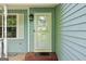 View of the home's light blue siding and white trimmed windows and a white framed glass front door at 1152 Sunday Ln, Jonesboro, GA 30238