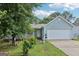 View of light blue home with a large two car garage and beautiful landscaping in the front lawn at 1152 Sunday Ln, Jonesboro, GA 30238
