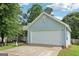 Close up of the home's light blue siding, two car garage, and concrete driveway with small lawn at 1152 Sunday Ln, Jonesboro, GA 30238