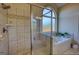 Bright bathroom with a tiled shower, frosted windows, and a soaking tub at 4180 Mount Paran Dr, Social Circle, GA 30025