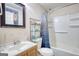 Bathroom with white tub-shower combo, modern vanity and fixtures and blue patterned shower curtain at 4180 Mount Paran Dr, Social Circle, GA 30025