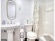 Bright bathroom with a shower with curtain and a pedestal sink and medicine cabinet at 4180 Mount Paran Dr, Social Circle, GA 30025