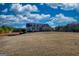 Charming two-story home with a long, paved driveway, surrounded by a spacious yard and lush greenery on a bright day at 4180 Mount Paran Dr, Social Circle, GA 30025