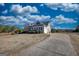 Beautiful home showcasing a well-maintained lawn and a long driveway leading to the residence under a cloudy blue sky at 4180 Mount Paran Dr, Social Circle, GA 30025