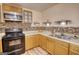 Kitchen with wood cabinets, stainless microwave, mosaic backsplash, and flooring rug at 4180 Mount Paran Dr, Social Circle, GA 30025
