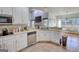 Charming kitchen with white cabinetry, stainless steel appliances, and a cozy breakfast nook overlooking the backyard at 4180 Mount Paran Dr, Social Circle, GA 30025