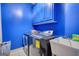 Laundry room with blue walls, washer, dryer, cabinets, and a sink at 4180 Mount Paran Dr, Social Circle, GA 30025
