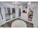 Organized walk-in closet features glass doors, built-in shelving, drawers, and modern lighting fixtures at 4180 Mount Paran Dr, Social Circle, GA 30025
