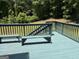 View of blue wooden back deck with benches and a wooded backyard at 2828 Hicks Sw Rd, Marietta, GA 30060