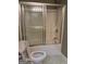 Modest bathroom features a standard shower-tub combo with sliding glass doors, toilet, sink and neutral finishes at 2828 Hicks Sw Rd, Marietta, GA 30060
