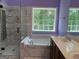 A luxurious bathroom featuring a shower, bath tub, double sinks, and large windows at 2828 Hicks Sw Rd, Marietta, GA 30060