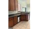 A kitchen with stainless steel dishwasher, double sink, and brown cabinets with bar access at 2828 Hicks Sw Rd, Marietta, GA 30060
