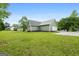 Expansive backyard featuring a lush lawn and mature trees, providing ample space for outdoor activities and relaxation at 106 June Ct, Hampton, GA 30228