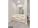 Bright bathroom showcasing a soaking tub with tile floors, and a window for lots of natural light at 106 June Ct, Hampton, GA 30228