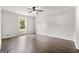 Well-lit bedroom with hardwood floors, neutral walls, ceiling fan and a large window at 106 June Ct, Hampton, GA 30228