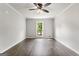 Well-lit bedroom with hardwood floors, neutral walls, ceiling fan and a large window at 106 June Ct, Hampton, GA 30228