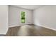 Bright bedroom with hardwood floors and a large window offering views of the surrounding greenery at 106 June Ct, Hampton, GA 30228