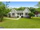 Charming single-story home featuring a well-maintained lawn, complemented by mature trees and classic shutters at 106 June Ct, Hampton, GA 30228