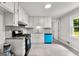 Updated kitchen featuring white cabinets, gray backsplash and countertop, with stainless steel appliances at 106 June Ct, Hampton, GA 30228