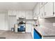 Updated kitchen featuring white cabinets, gray backsplash and countertop, with stainless steel appliances at 106 June Ct, Hampton, GA 30228