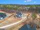 Aerial view of a modern farmhouse with mature trees, a long drive, and a neighboring pool at 260 Cicely Way, Tyrone, GA 30290