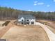 Aerial view of a modern farmhouse with mature trees, a long drive, and a sprawling lawn at 260 Cicely Way, Tyrone, GA 30290