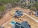 An aerial view of a new home with a large lot, a sparkling pool, a long driveway and mature trees at 260 Cicely Way, Tyrone, GA 30290