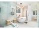 Bright, tiled bathroom with stand alone tub, glass enclosed shower, and elegant chandelier at 260 Cicely Way, Tyrone, GA 30290
