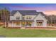 Stunning two-story home features a classic white exterior with dark trim and a welcoming front porch at 260 Cicely Way, Tyrone, GA 30290