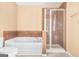 Bathroom featuring a soaking tub with tiled walls and a glass shower at 6533 Waterford Sw St, Atlanta, GA 30331