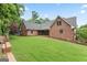 Brick home's backyard featuring manicured lawn, mature trees, and outdoor living space at 510 Jenna Trl, Mcdonough, GA 30252