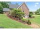 Landscaped yard with brick wall and well-maintained lawn and a brick home with a garage at 510 Jenna Trl, Mcdonough, GA 30252