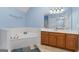 Spacious bathroom featuring a soaking tub, wood vanity, and tranquil 'Peace, Love, and Joy' wall decor at 510 Jenna Trl, Mcdonough, GA 30252