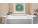 Close-up of an elegant soaking tub with decorative tile surround, natural lighting, and hardware at 510 Jenna Trl, Mcdonough, GA 30252